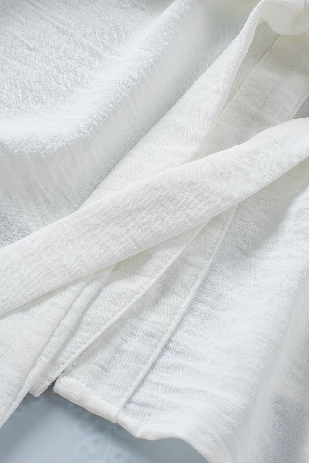 Chemise blanche sans manches à col fendu et cordon de serrage à la taille