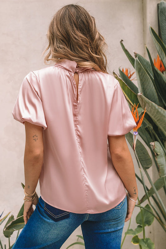 Blouse en satin rose torsadée à col haut et manches bouffantes