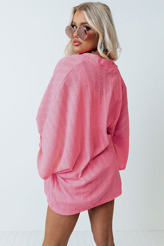 Cardigan en tricot rose à manches kimono ouvert sur le devant