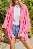 Cardigan en tricot rose à manches kimono ouvert sur le devant