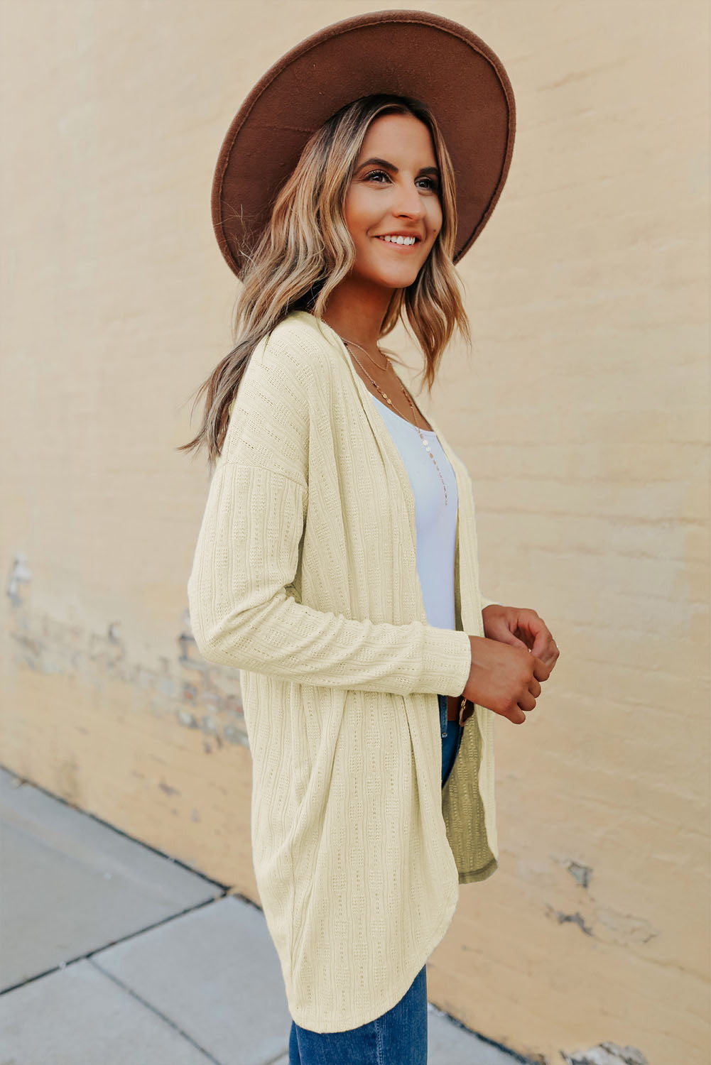 Cardigan beige en maille texturée, ouvert sur le devant, ourlet arrondi 