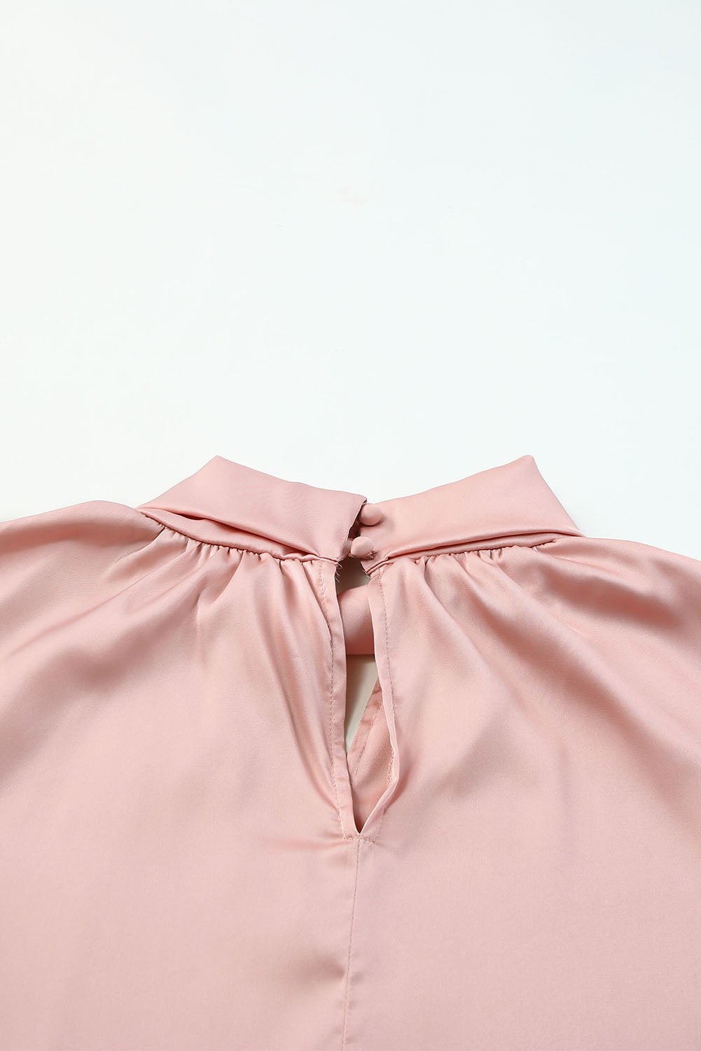 Blouse en satin rose torsadée à col haut et manches bouffantes