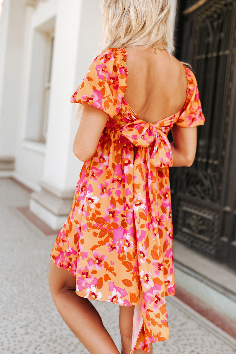 Mini-robe florale orange à manches bouffantes et nœud papillon dans le dos ouvert