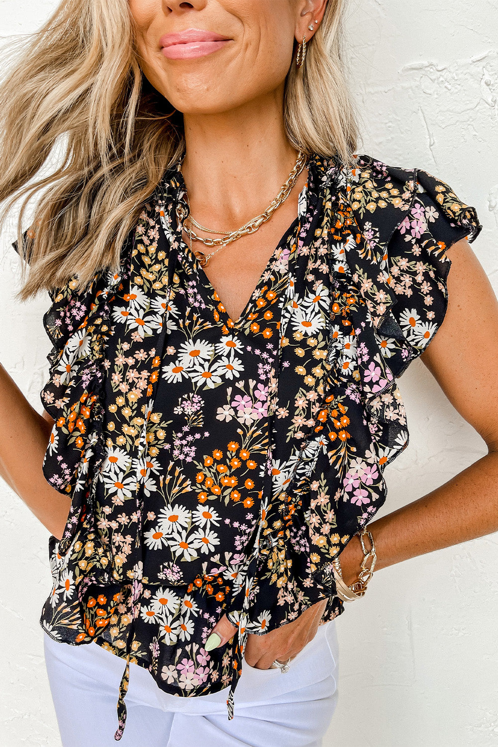 Blouse noire à col en V et cordon de serrage à volants et imprimé floral