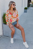 Blouse orange à manches bouffantes et à volants et fleurs épanouies