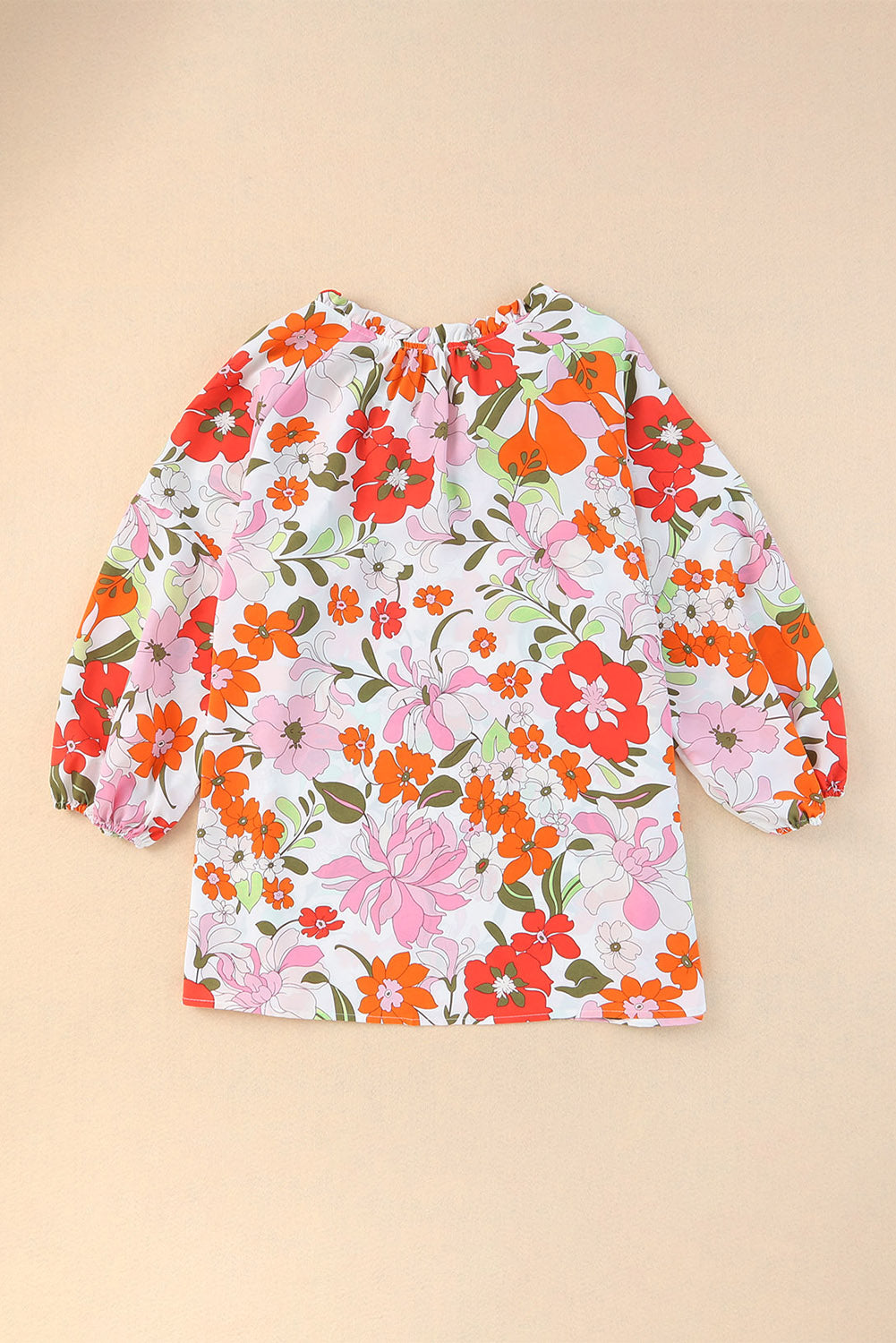 Blouse orange à manches bouffantes et à volants et fleurs épanouies