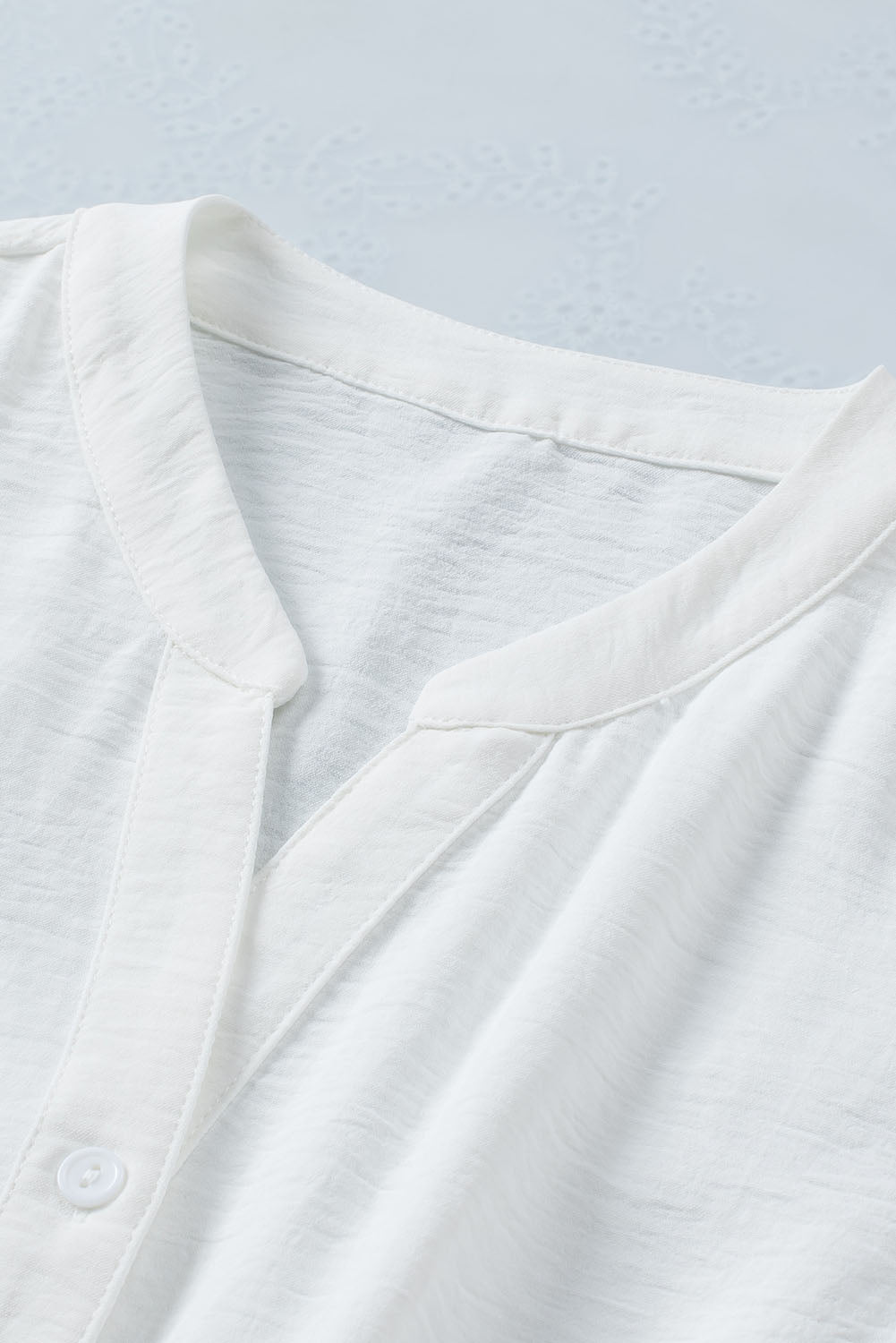 Chemise blanche sans manches à col fendu et cordon de serrage à la taille