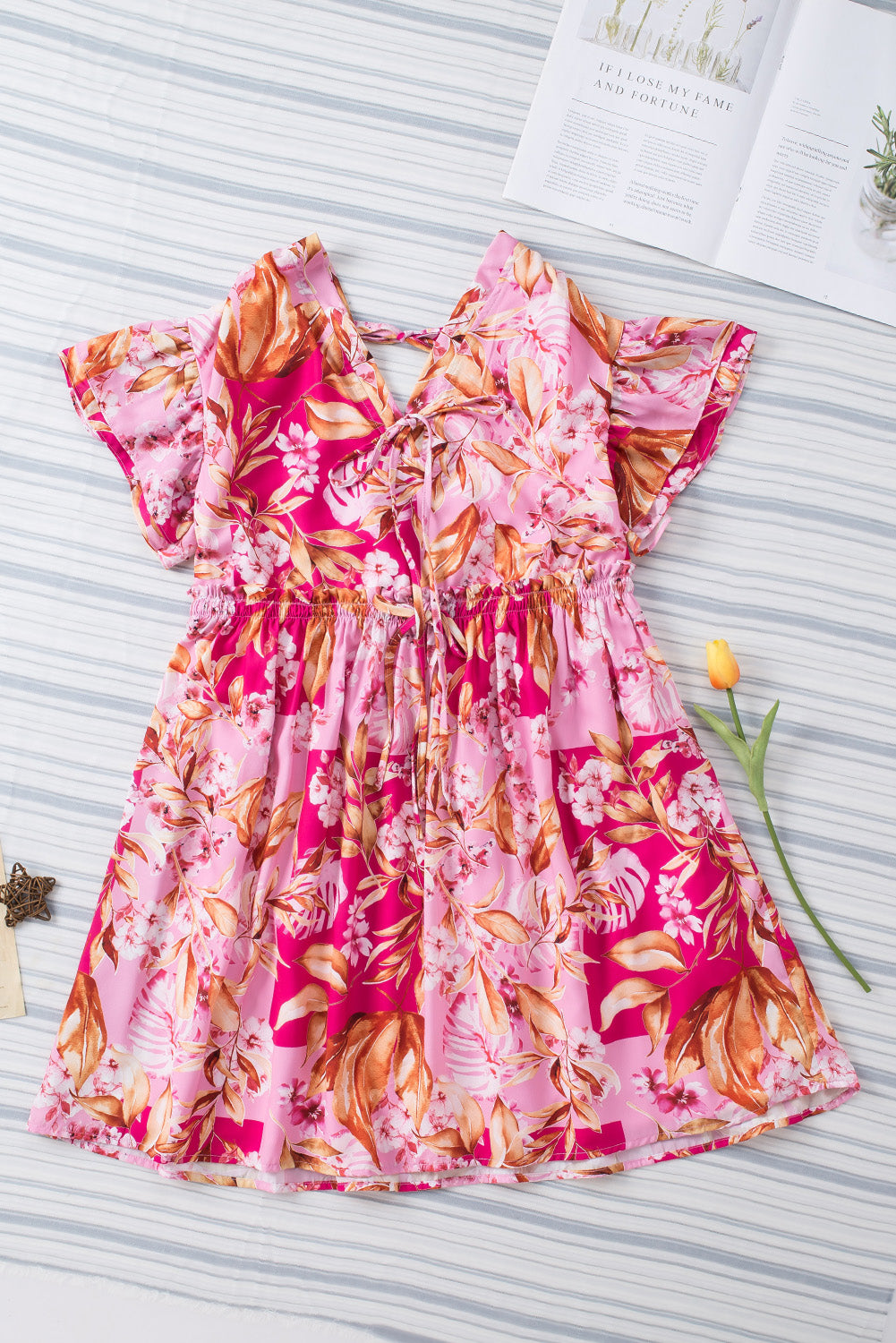 Robe florale rose avec nœud papillon et dos ouvert, col en V