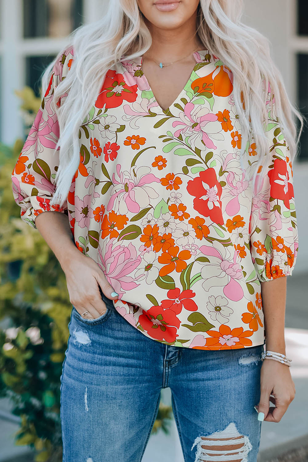 Blouse orange à manches bouffantes et à volants et fleurs épanouies