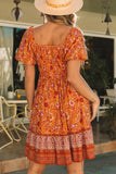 Robe fleurie fluide orange à col carré et manches bouffantes