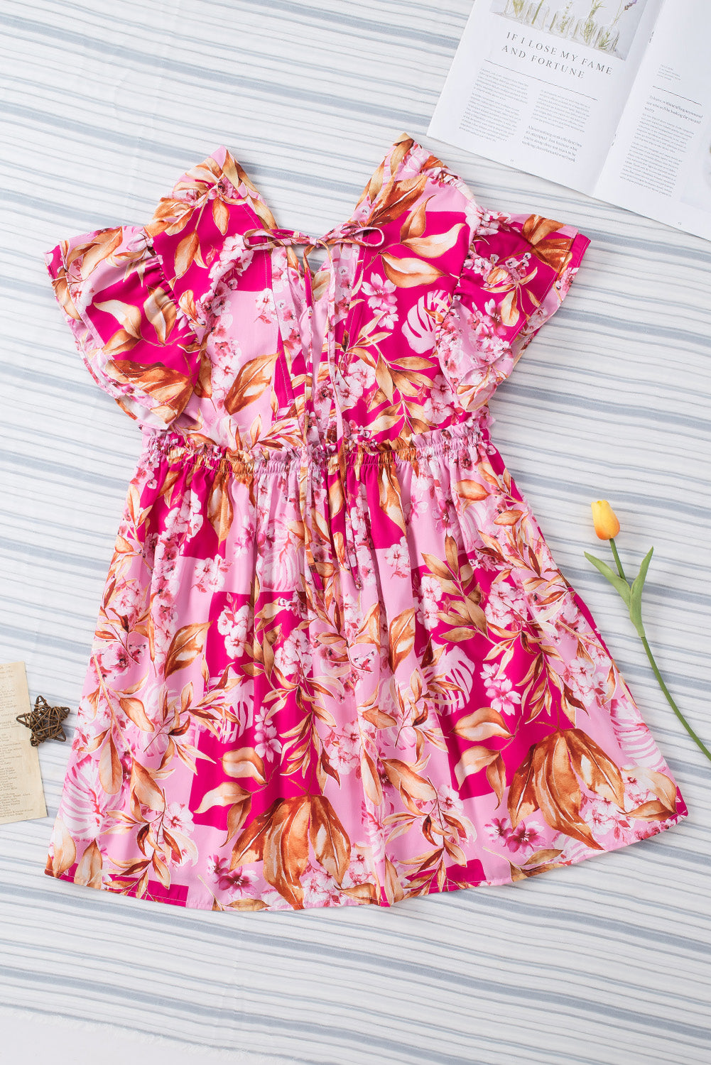 Robe florale rose avec nœud papillon et dos ouvert, col en V