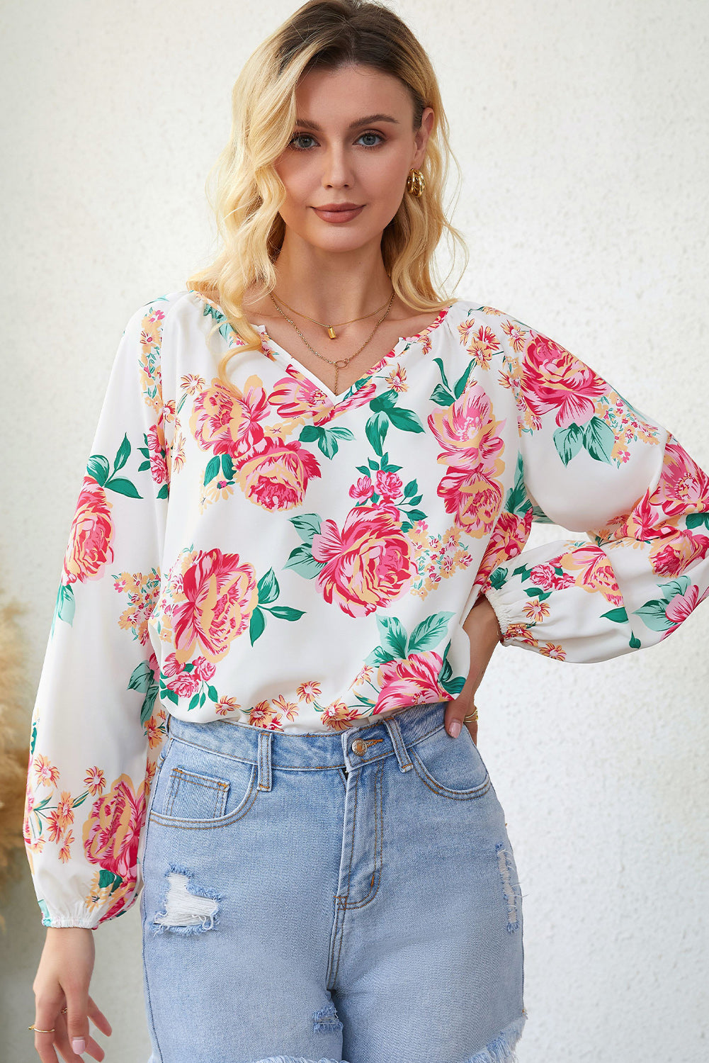 Blouse blanche à manches bouffantes et plissée florale à col en V