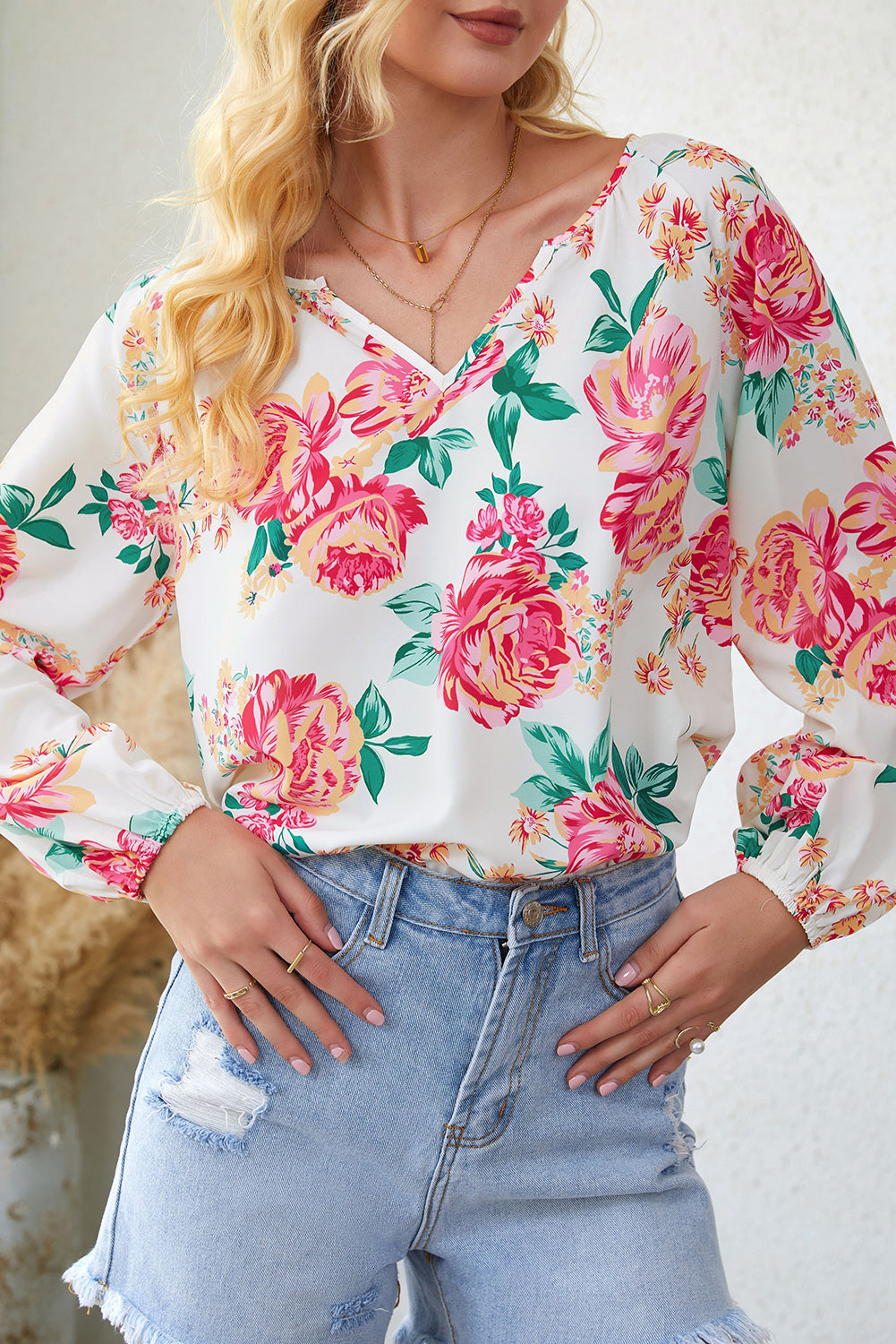 Blouse blanche à manches bouffantes et plissée florale à col en V