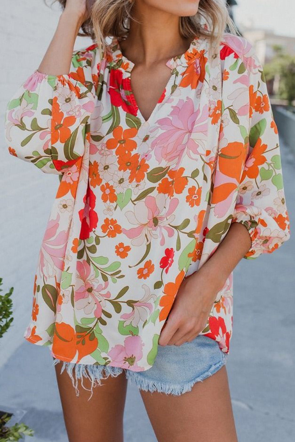 Blouse orange à manches bouffantes et à volants et fleurs épanouies