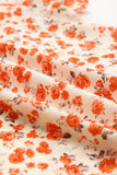 Blouse fleurie orange à manches flottantes et à plusieurs niveaux