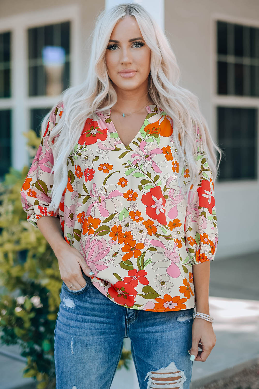 Blouse orange à manches bouffantes et à volants et fleurs épanouies