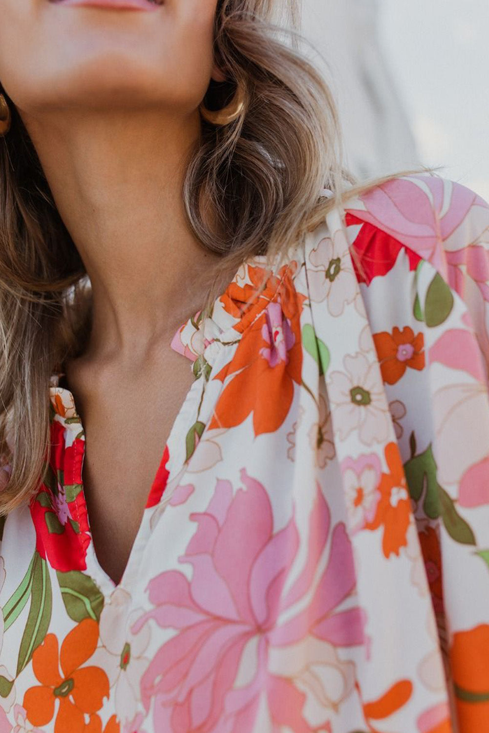 Blouse orange à manches bouffantes et à volants et fleurs épanouies