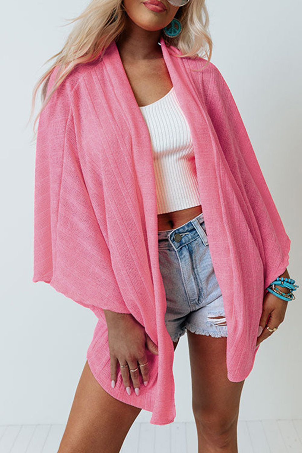 Cardigan en tricot rose à manches kimono ouvert sur le devant