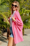 Cardigan en tricot rose à manches kimono ouvert sur le devant