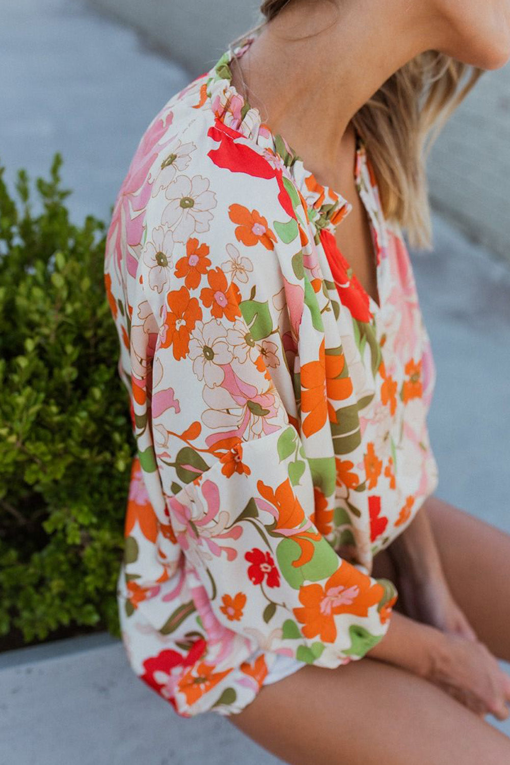 Blouse orange à manches bouffantes et à volants et fleurs épanouies