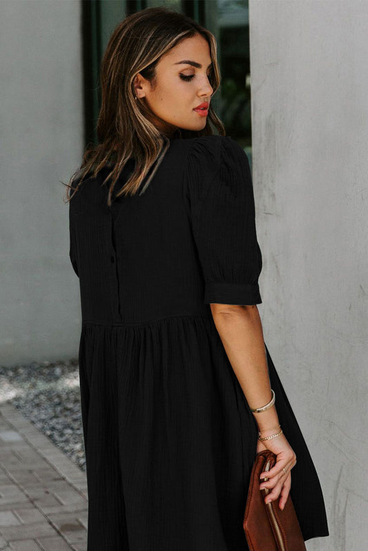 Robe courte noire avec poches bouffantes et taille empire