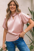 Blouse en satin rose torsadée à col haut et manches bouffantes