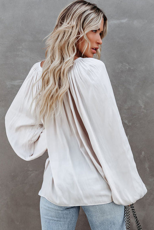 Blouse blanche en satin plissée à col en V et manches bouffantes