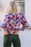 Blouse bleue à imprimé floral et manches bouffantes à col montant