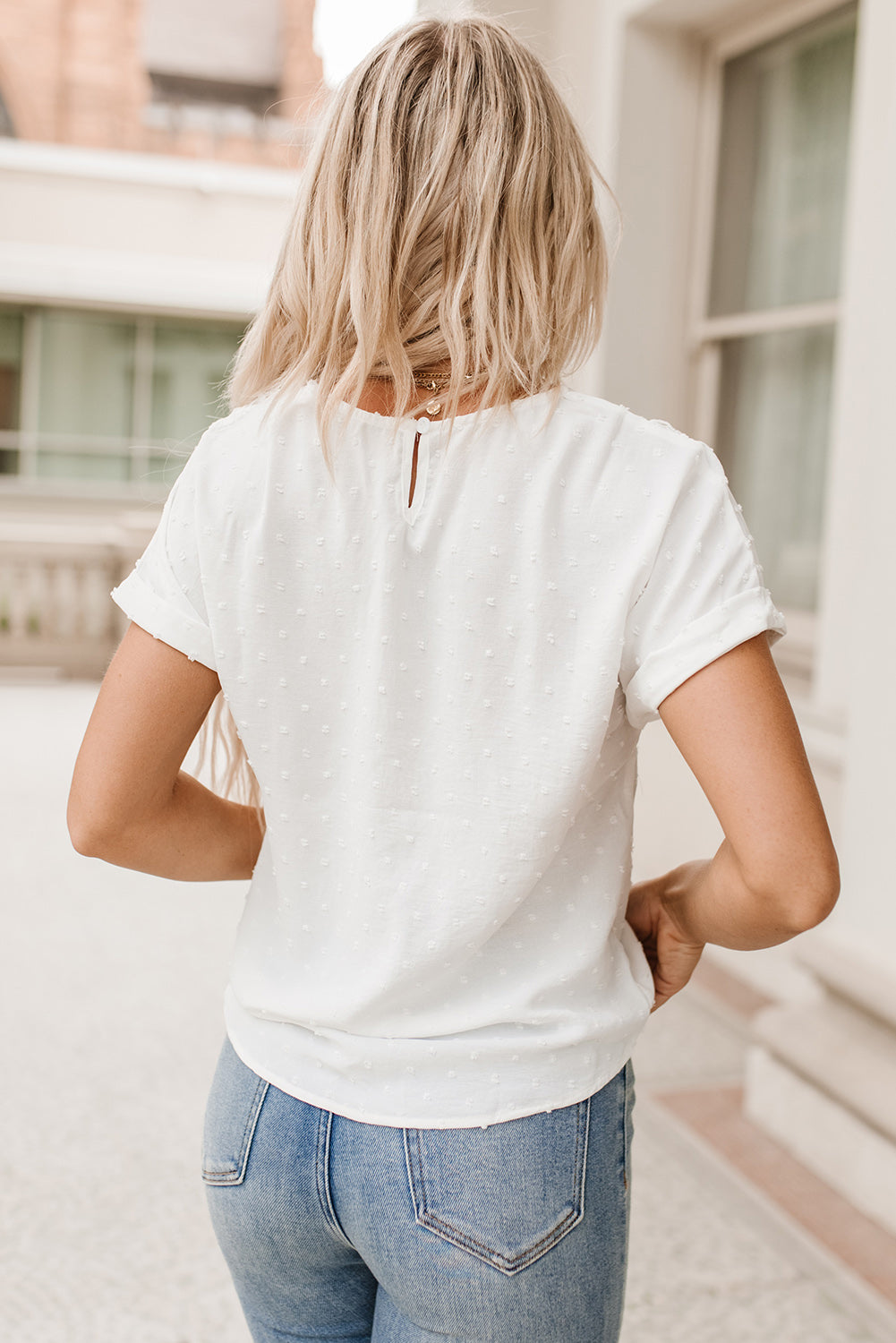 Haut blanc en dentelle à pois et manches à revers