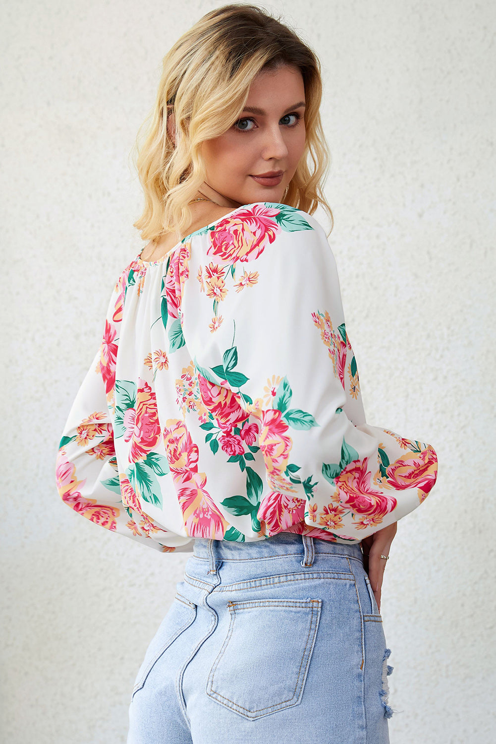 Blouse blanche à manches bouffantes et plissée florale à col en V