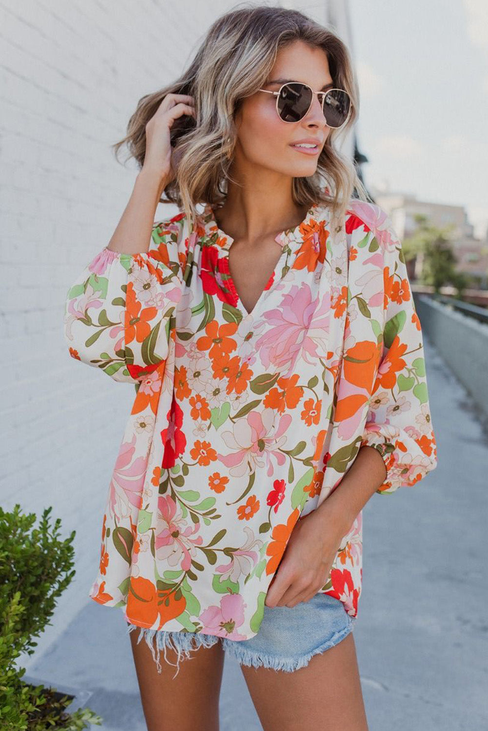 Blouse orange à manches bouffantes et à volants et fleurs épanouies