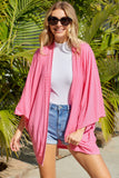 Cardigan en tricot rose à manches kimono ouvert sur le devant