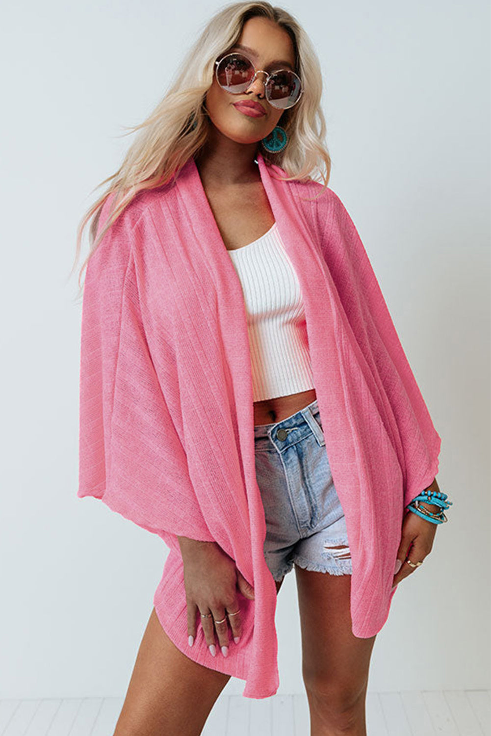 Cardigan en tricot rose à manches kimono ouvert sur le devant