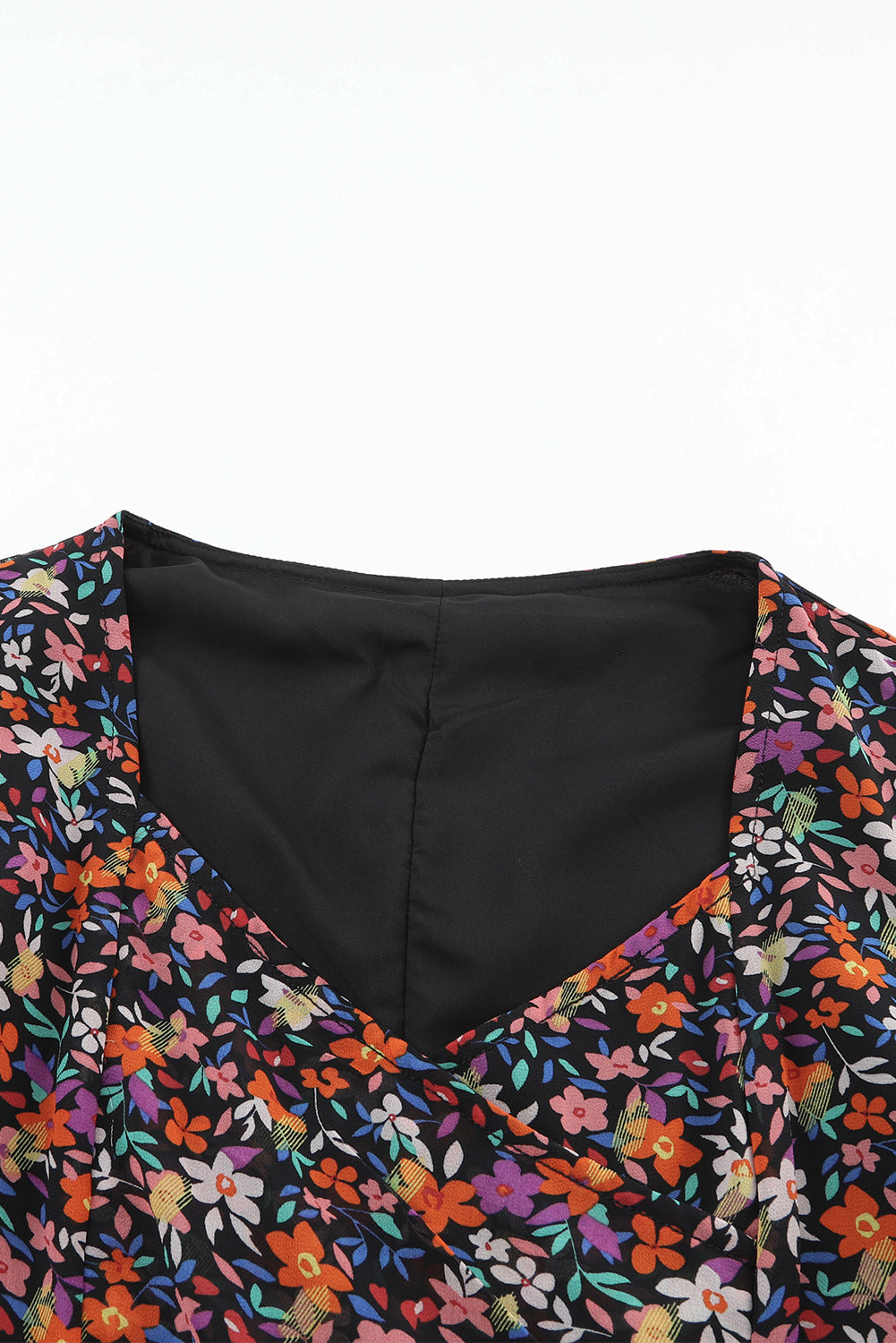 Blouse florale noire à col en V et manches bouffantes