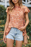 Blouse florale orange à col volanté