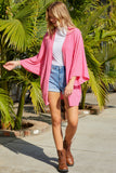 Cardigan en tricot rose à manches kimono ouvert sur le devant