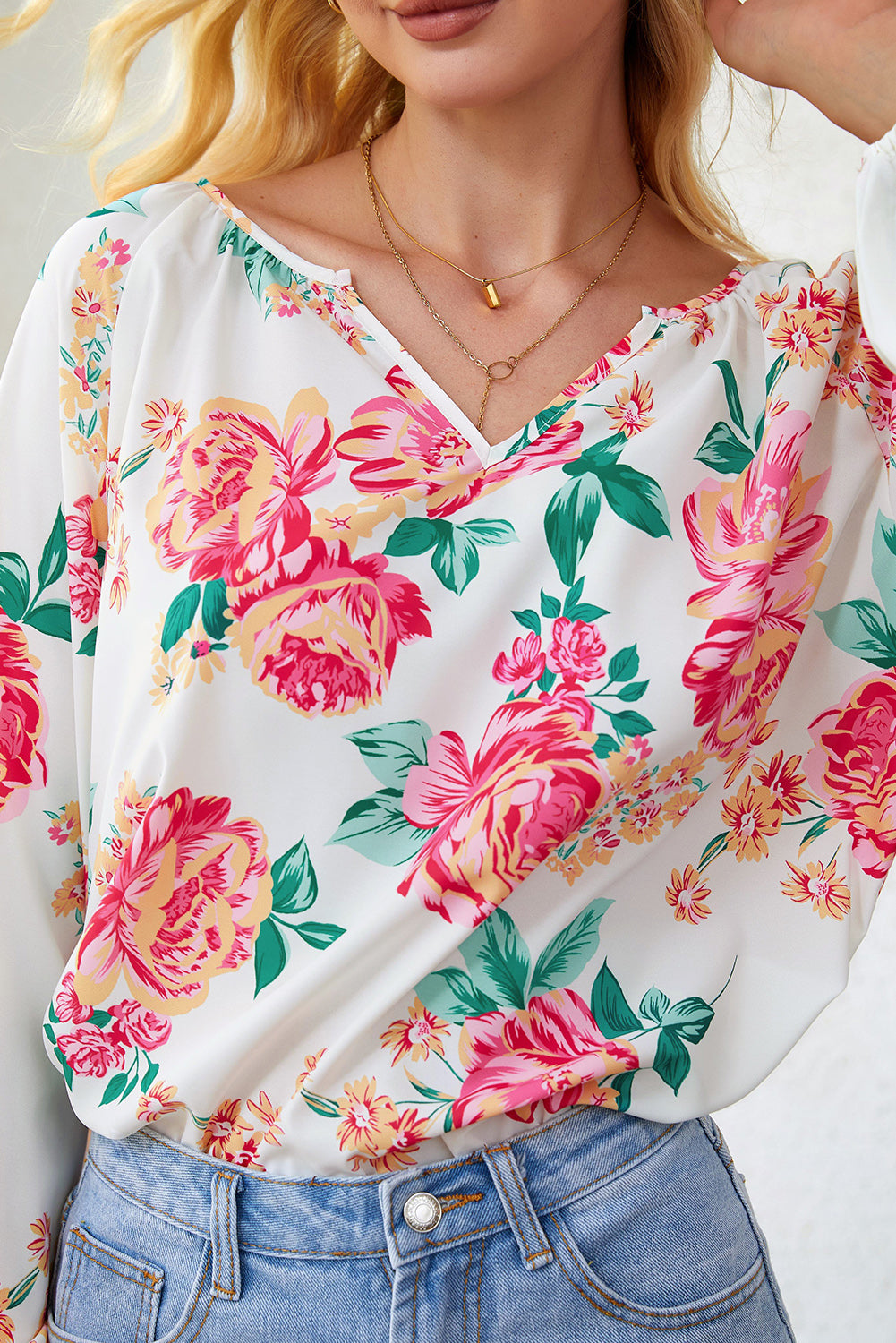 Blouse blanche à manches bouffantes et plissée florale à col en V