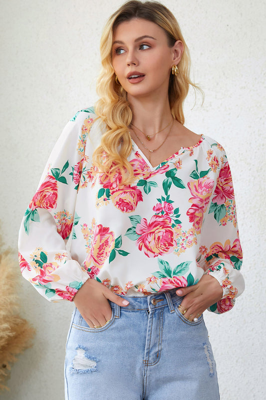 Blouse blanche à manches bouffantes et plissée florale à col en V