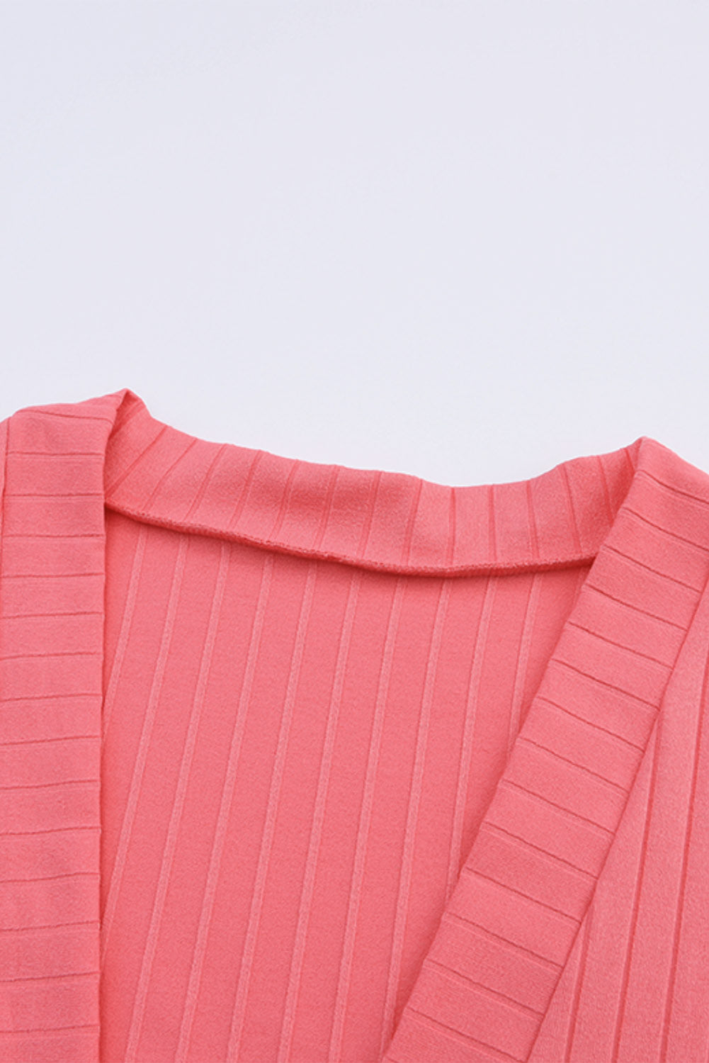 Cardigan en tricot rose ouvert avec poches sur le devant