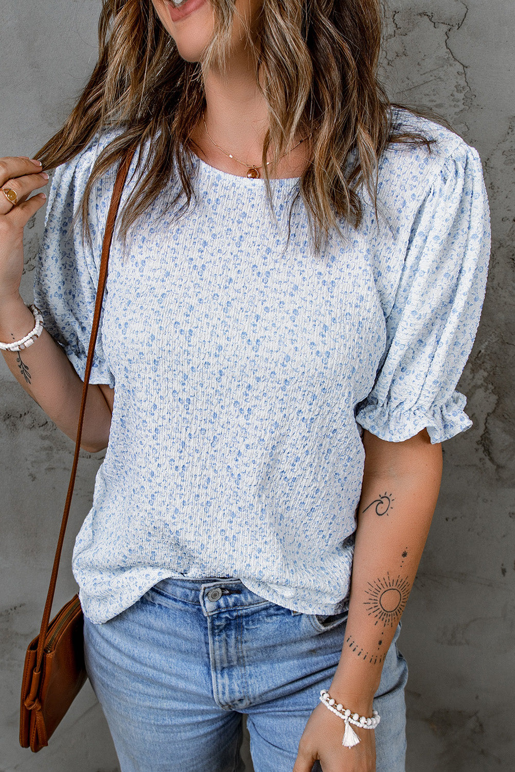 Blouse noire à manches bouffantes et smockée à fleurs