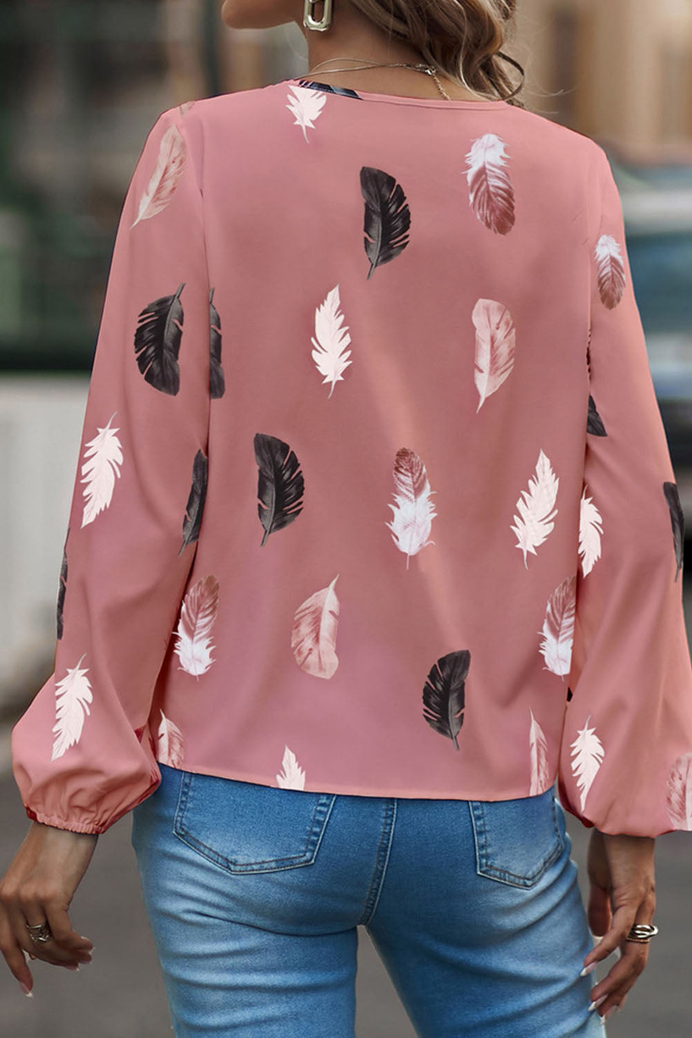 Blouse rose à imprimé plumes et col en V