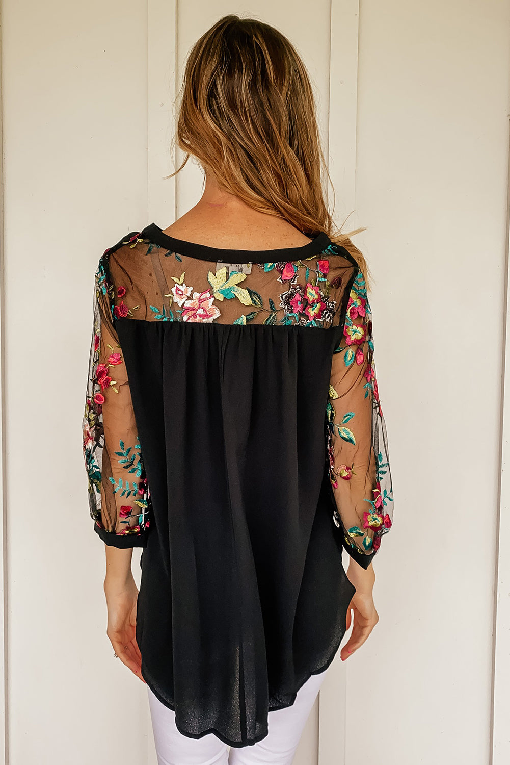 Blouse noire à manches brodées de fleurs