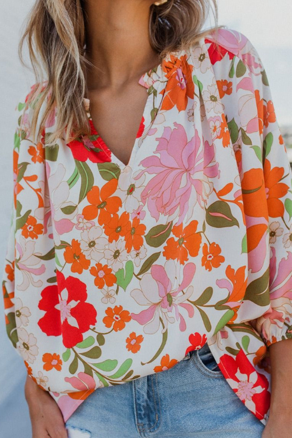 Blouse orange à manches bouffantes et à volants et fleurs épanouies