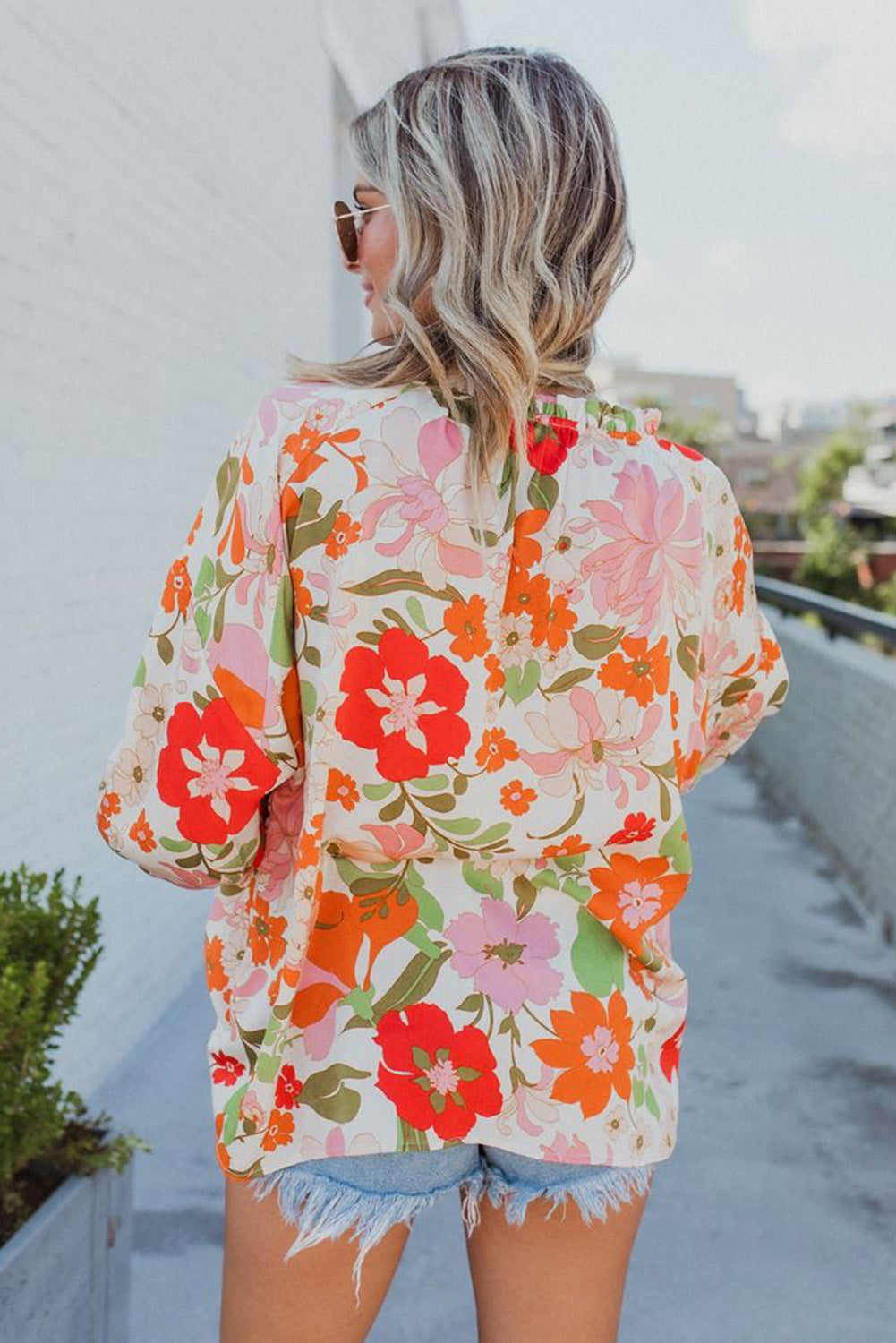 Blouse orange à manches bouffantes et à volants et fleurs épanouies